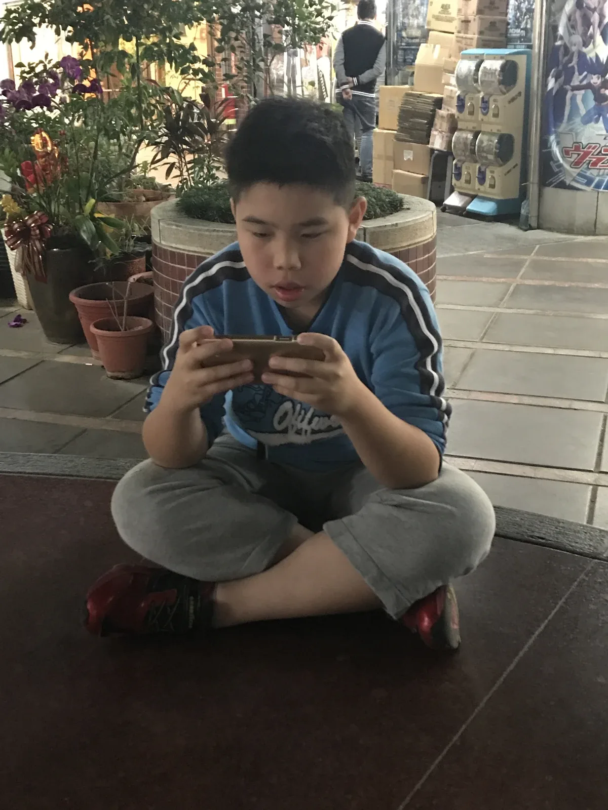 Foto arkib kanak-kanak bermain permainan pada telefon pintar, Mac 2018. &mdash; Foto: 玄史生 melalui Wikimedia Commons.