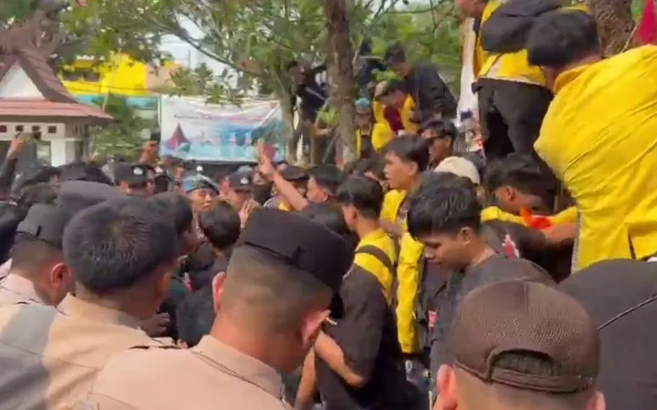 Peserta demonstrasi di pagar bangunan DPRD Kalimantan Selatan